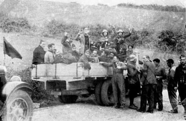 Combatientes expedicionarios vascos a punto de ser trasladados en camionetas, durante un relevo en el frente asturiano.